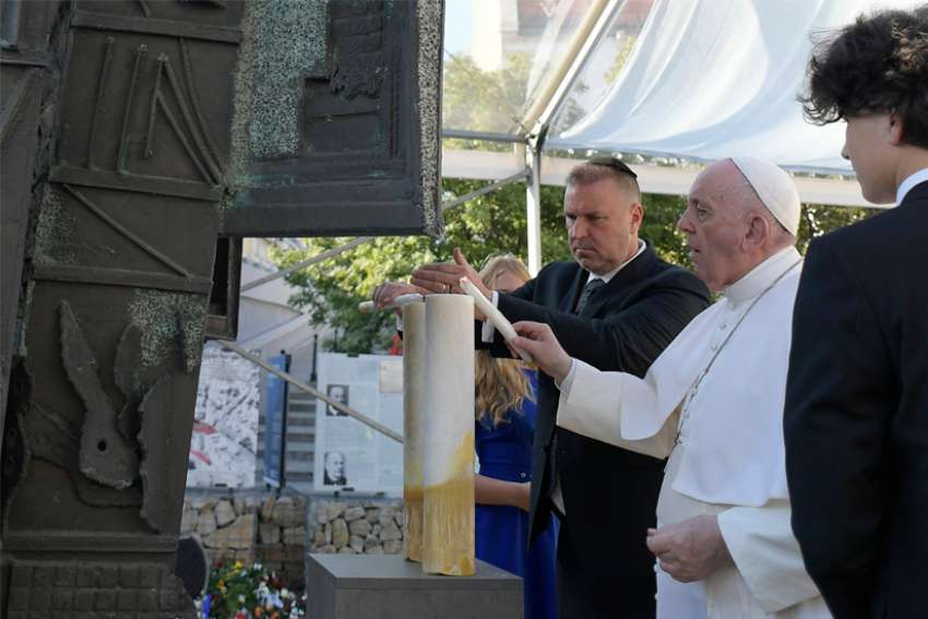 Pope Francis and Richard Duda, president of the Federation of Jewish Communities in Slovakia, light candles during a meeting with the Jewish community in Rybné námestie Square in Bratislava, Slovakia, Sept. 13, 2021.