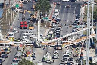 An aerial view shows a pedestrian bridge that collapsed March 15 at Florida International University in Miami. Authorities in Florida&#039;s Miami-Dade area said at least six people have died but the number could rise as they search through the rubble. 