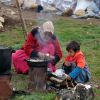 A female refugee from Syria prepares food for her family as her son helps her with the stove Nov. 22 at a refugee camp in the village of Jeb Jennine, in Lebanon&#039;s Bekaa Valley. No one is sure how many refugees from Syria have already arrived in Lebanon.
