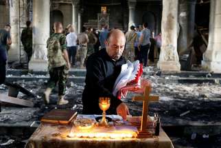 An Iraqi man prepares a makeshift altar for the first Sunday Mass Oct. 30, 2016 at the Church of the Immaculate Conception in Qaraqosh after it was recaptured from Islamic State militants.