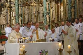 Fr. Michael Hartney, centre, celebrates his first Mass with Ottawa Archbishop Terrence Prendergast, left.