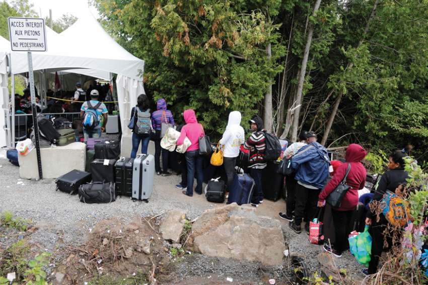 A group of Haitians wait to cross the U.S.-Canada border into Quebec from New York.