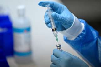 A health care worker prepares a dose of the COVID-19 vaccine at a clinic in Montreal.
