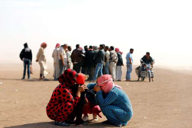Syrian refugees wait at the Turkish border near Sanliurfa, Sept. 24. Some Syrian refugees in Jordan say they welcome the military intervention to diminish Islamic State power, while others blame Syrian President Bashar Assad for turning a &quot;blind eye&quot; to infiltration by foreign militants.