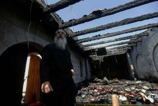 A clergyman stands inside the Church of Loaves and Fishes following a 2015 fire in Tabgha, Israel. Twenty months after having suffered serious damage from an arson attack, the atrium of the Benedictine church was reopened.