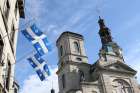 Quebec provincial flags are displayed outside a building across the street from the Cathedral-Basilica of Notre-Dame de Quebec in Quebec City Oct. 5, 2017.