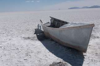 An abandoned boat lies several hundred feet from the shore of Lake Poopo in Llapallapani, Bolivia. The lake dried up three years ago and 30 million fish died almost overnight.