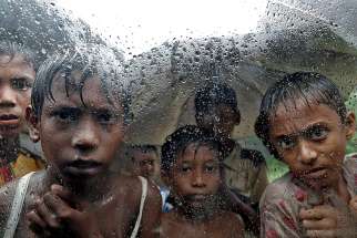 Rohingya refugee children are seen through a rain-covered window Sept. 19 at a camp in Cox&#039;s Bazar, Bangladesh. 