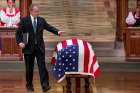  Former U.S. President George W. Bush touches the flag-draped casket of former President George H.W. Bush after speaking at his father&#039;s state funeral Dec. 5 at the Episcopal Church&#039;s Washington National Cathedral. 