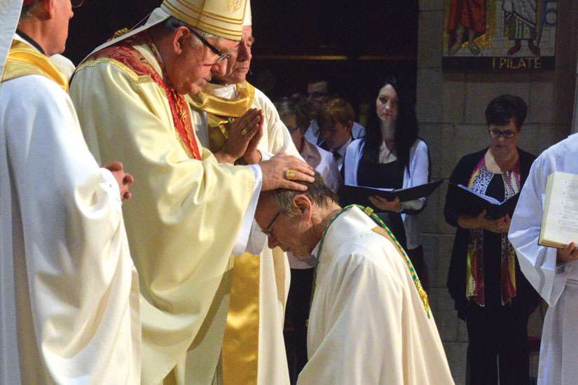 Cardinal Thomas Collins lays his hands on the head of newly ordained Bishop Robert Kasun.  Kasun was ordained a bishop Sept. 12 in Edmonton and will be an auxiliary bishop of Toronto.