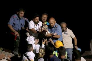 A doctor and an officer from the Italian Carabinieri police force carry a child Aug. 22 after an earthquake hit Ischia, Italy. The earthquake rattled the Italian resort island at the peak of tourist season the evening of Aug. 21, killing at least two people and trapping others under collapsed homes.