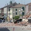People walk past a collapsed building after an earthquake in Cavezzo, Italy, May 29. The magnitude 5.8 earthquake struck northern Italy, killing at least 10 people as factories, warehouses and a church collapsed in the same region still struggling to recover from another quake nine days earlier.