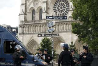 Police officers establish a security parameter outside Notre Dame Cathedral in Paris June 6 after police shot and injured a man who attacked officers with a hammer in the square outside the church.