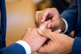 Two same-sex partners exchange wedding bands during a 2017 ceremony at the civil registry office in Munich. 