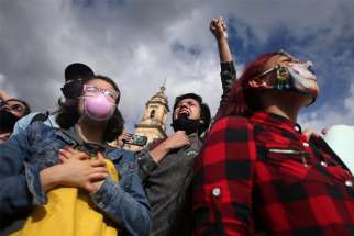 People react during a protest against police actions in Bogota, Colombia, Sept. 13, 2020.