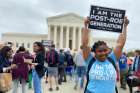 Norvilia Etienne, of Students for Life, holds a sign outside the Supreme Court of the United States May 3, 2022, the day after a draft of the court&#039;s opinion was leaked signaling that the court was leaning toward overturning Roe v. Wade.