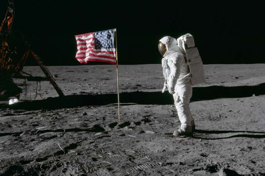 Astronaut Edwin &quot;Buzz&quot; Aldrin, lunar module pilot of the first lunar landing mission, poses for a photograph beside the deployed U.S. flag during an Apollo 11 extra-vehicular activity on the lunar surface July 20, 1969.