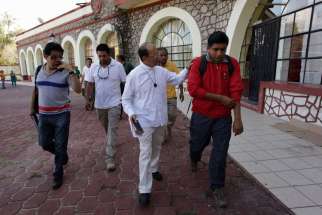Father Alejandro Solalinde Guerra, a human rights activist, center, walks after an Oct. 26 meeting with Ayotzinapa Teacher Training College &quot;Raul Isidro Burgos&quot; students, in Ayotzinapa. Mexico. Forty-three students went missing in Iguala, Mexico, Sept. 2 6 after clashing with police and masked men. Authorities fear that the 43 missing trainee teachers could have been massacred by police in league with gang members.