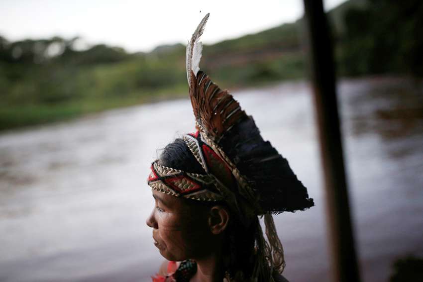 An indigenous woman from the Pataxo Ha-ha-hae tribe looks over the Paraopeba River in Brazil Jan. 28, 2019, after a tailings dam owned by Brazilian mining company Vale SA collapsed. 