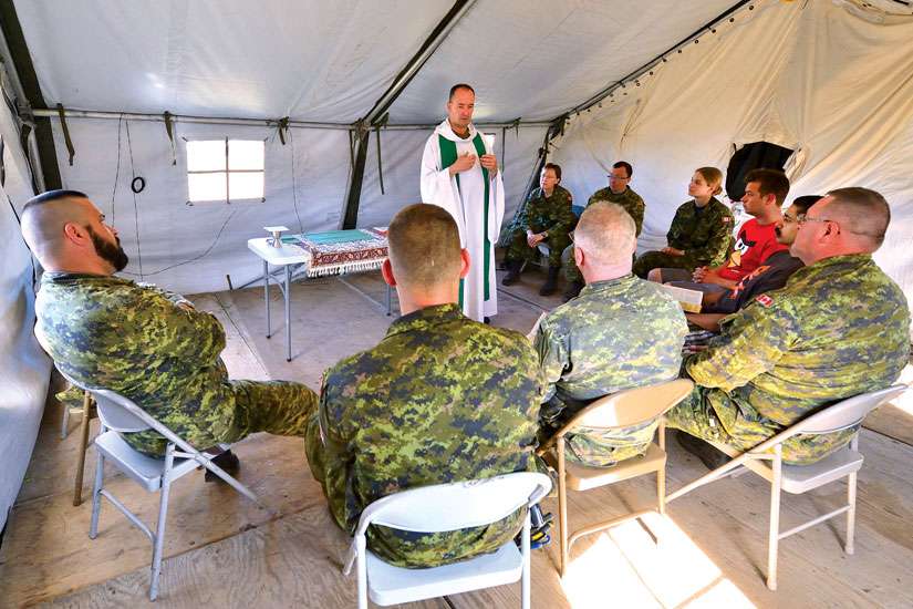 Padre Tim Nelligan, Senior Chaplain from Edmonton, presides over the holy Mass at Airfield 21 in Wainwright, Alta. Chaplains are the sounding board for soldiers who are dealing with the demons from their service.