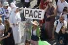 A woman holds up a sign that say &quot;Pace,&quot; peace in Italian, as Pope Francis appeals for an end to the fighting between Israel and Palestine after reciting the Angelus prayer Oct. 8, 2023, with visitors in St. Peter&#039;s Square at the Vatican.