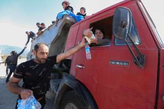 David Harapetyan, an ethnic Armenian and taxi driver who came from the Russian city of Stavropol to lend assistance, hands over food and water to refugees fleeing from Azerbaijan&#039;s Nagorno-Karabakh region as they arrive in the border village of Kornidzor, Armenia, Sept. 27, 2023.
