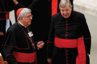 Cardinal Thomas Collins of Toronto and Australian Cardinal George Pell, prefect of the Vatican Secretariat for the Economy, talk after an event marking the 50th anniversary of the Synod of Bishops in Paul VI hall at the Vatican Oct. 17.