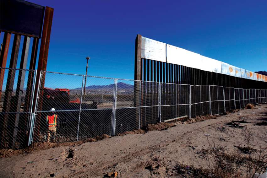 A worker stands at the U.S.-Mexico border wall at Sunland Park, N.M., opposite the Mexican border city of Ciudad Juarez.