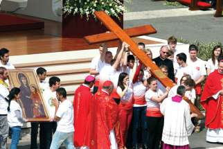 Young people from Poland accept the World Youth Day cross from Brazilian youths at Palm Sunday Mass in St. Peter’s Square April 13. World Youth Day will be July 25-Aug. 1, 2016, in Krakow, Poland
