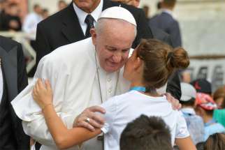 Pope Francis greets a young woman as he arrives for his general audience in St. Peter&#039;s Square at the Vatican Aug. 28, 2019.