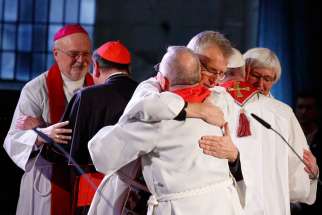 The Rev. Martin Junge, general secretary of the Lutheran World Federation, embraces a Catholic representative as Pope Francis embraces Archbishop Antje Jackelen, primate of the Lutheran Church in Sweden, right, during an ecumenical prayer service at the Lutheran cathedral in Lund, Sweden, Oct. 31.