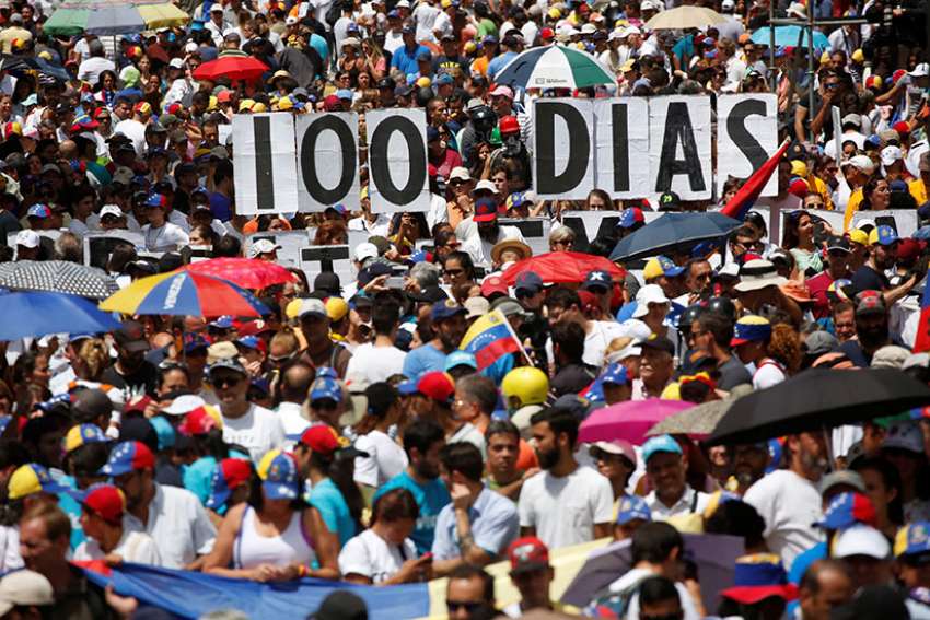 Opposition supporters hold letters to build a banner that reads &quot;100 days&quot; during a July 9 protest against Venezuelan President Nicolas Maduro&#039;s government in Caracas.
