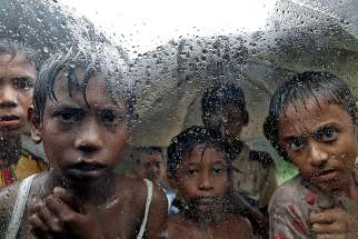 Rohingya refugee children are seen through a rain-covered window Sept. 2017 at a camp in Cox&#039;s Bazar, Bangladesh. 