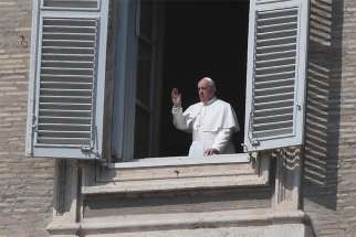 Pope Francis is seen in a window greeting a few nuns standing in St. Peter&#039;s Square at the Vatican March 22, 2020, after reciting his weekly Angelus prayer from the library of the Apostolic Palace. The pope announced he will give an extraordinary blessing &quot;urbi et orbi&quot; (to the city and the world) at 6 p.m. Rome time March 27 in an &quot;empty&quot; St. Peter&#039;s Square because all of Italy is on lockdown to prevent further spread of the coronavirus.