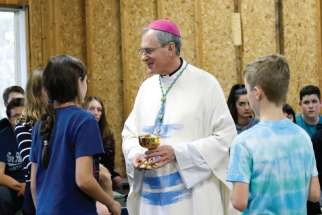 Bishop Ronald P. Fabbro talks with young people during CCLC week, a summer camp run by the London diocese. 