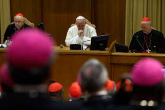 Pope Francis attends the morning session on the final day of the extraordinary Synod of Bishops on the family at the Vatican Oct. 18. At left is Cardinal Lorenzo Baldisseri, general secretary of the Synod of Bishops, and at right Cardinal Peter Erdo of E sztergom-Budapest, Hungary, relator for the synod.