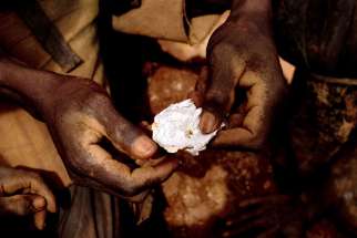 A mineworker in Chudja, Congo, shows a small piece of gold found after water processing in this June 2009 file photo. Congo’s Catholic bishops criticized the failure of Wester governments to stop the abuse of Congo’s natural resources.