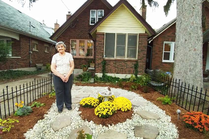 Bess Srahulek showcases her new garden. Students and neighbours worked to repair the damage to her garden caused by a rowdy homecoming street party. 