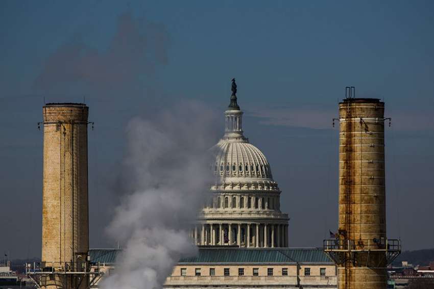 The dome of the U.S. Capitol is seen behind the smokestacks of the only coal-burning power plant in Washington in this March 10, 2014, file photo.