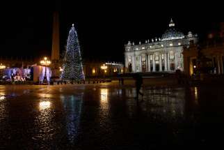 The St. Peter&#039;s Square Christmas tree is reflected in a puddle of slush after a five-minute hail storm hit the Vatican Feb. 1. 