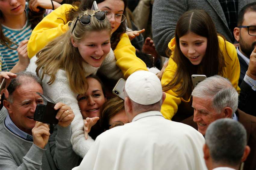 People greet Pope Francis as he leaves his general audience in Paul VI hall at the Vatican Dec. 18, 2019.
