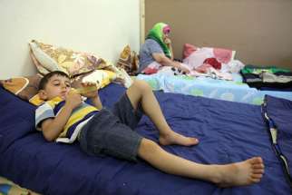 An Iraqi Christian child who fled from violence in Mosul, Iraq, lies on a bed in late August at a church in Amman, Jordan. A Catholic official warned that funding will soon run out for the refugees, who fled Islamic State militants.