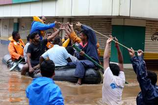 Rescue workers evacuate people from flooded areas Aug. 16 after the opening of a dam following heavy rains on the outskirts of Cochin, India. The Catholic Church has joined relief efforts as unprecedented floods and landslides continue to wreak havoc in India&#039;s Kerala state, killing at least 75 people within a week. 