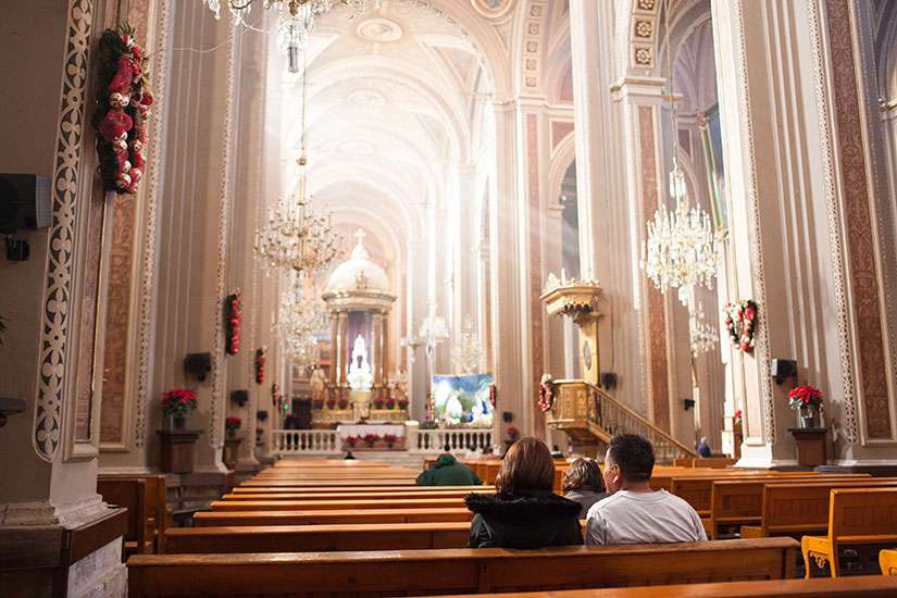 People pray inside the Morelia cathedral Dec. 17 in Mexico.