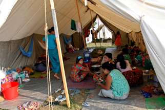 Displaced Rakhine people who fled fighting eat their meal inside a temporary shelter in late October in Sittwe, Myanmar. Fighting has intensified between the Myanmar military and armed ethnic groups.