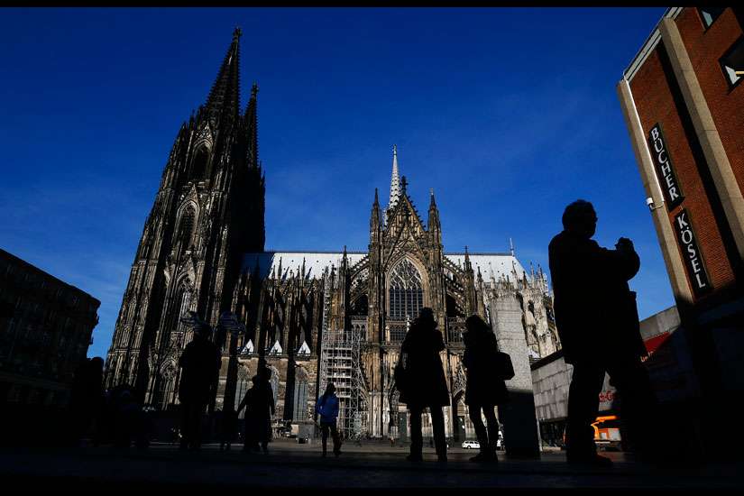 People are silhouetted against the Cologne Cathedral in Germany Jan. 25. Catholic bishops in Germany and Austria urged their countries to continue accepting refugees, despite demands for new restrictions after New Year&#039;s Eve violence in Cologne and other cities.