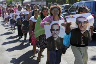People hold posters showing the image of St. Oscar Romero during a 2014 protest in San Salvador, El Salvador. The protest was against the decision of the mayor to name a street after deceased Army Maj. Roberto D&#039;Aubuisson, allegedly the mastermind of the 1980 killing of St. Romero. 