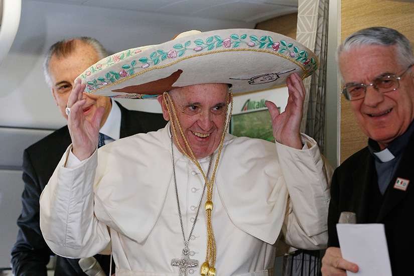 Pope Francis tries on a sombrero while meeting journalists aboard his flight to Havana Feb. 12. Traveling to Mexico for a six-day visit, the pope is stopping briefly in Cuba to meet with Russian Orthodox Patriarch Kirill of Moscow at the Havana airport.