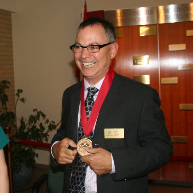 Novalis Publishing Director Joe Sinasac takes his turn wearing the St. Eugene de Mazenod Medal awarded to Novalis July 7 by Saint Paul University Rector Chantal Beauvais.