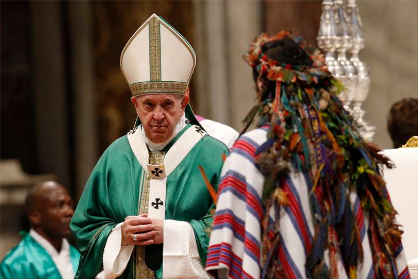 Pope Francis accepts offertory gifts from an indigenous man as he celebrates the concluding Mass of the Synod of Bishops for the Amazon at the Vatican Oct. 27, 2019.